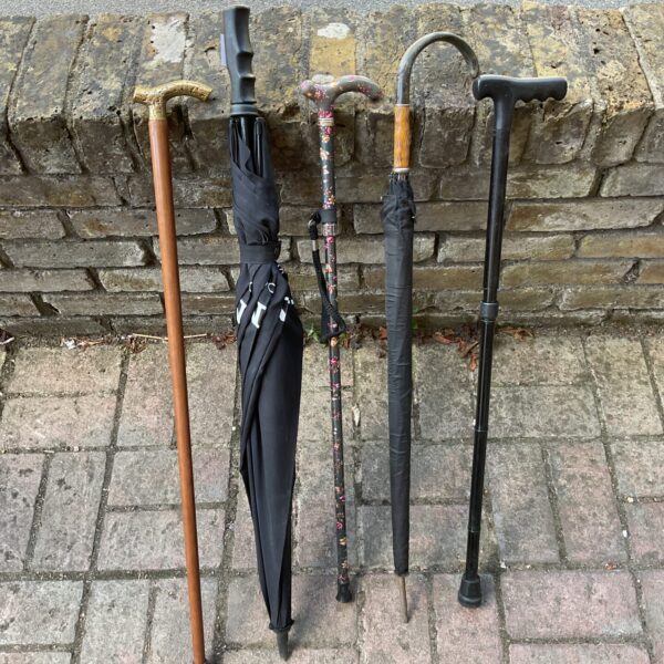 Bundle of vintage walking sticks and a black Sony umbrella.