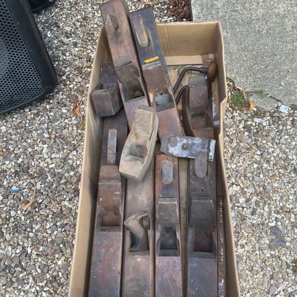 Vintage woodblock planes in a cardboard box, antique woodworking tools.