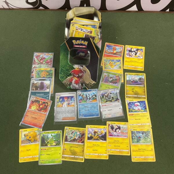 Assorted Pokemon cards inside a metal tin.