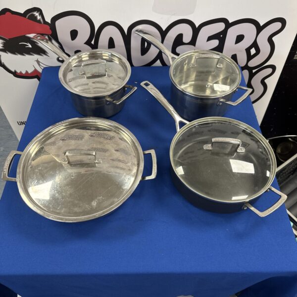 Four Le Creuset stainless steel cooking pans (one pan has incorrect lid)