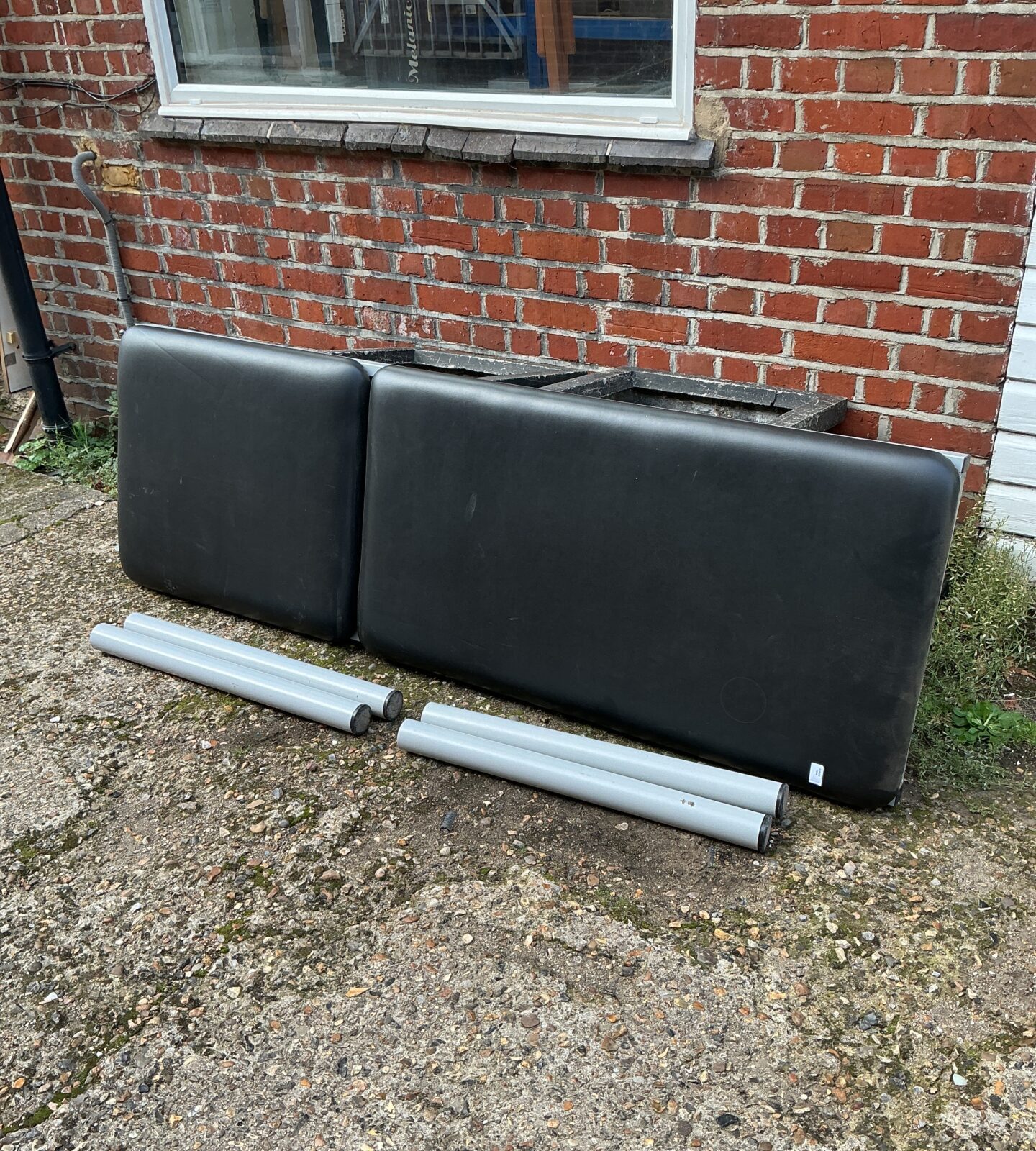 Black faux leather massage table sections for therapy or spa use.