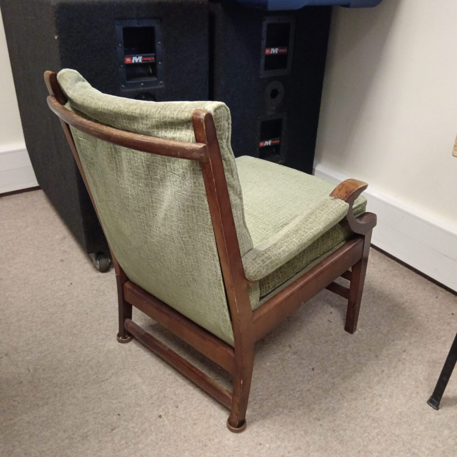 Side view of a green mid-century armchair.