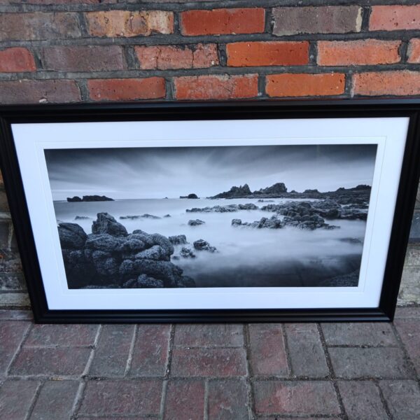 Large framed print of a misty rocky shoreline for coastal decor.