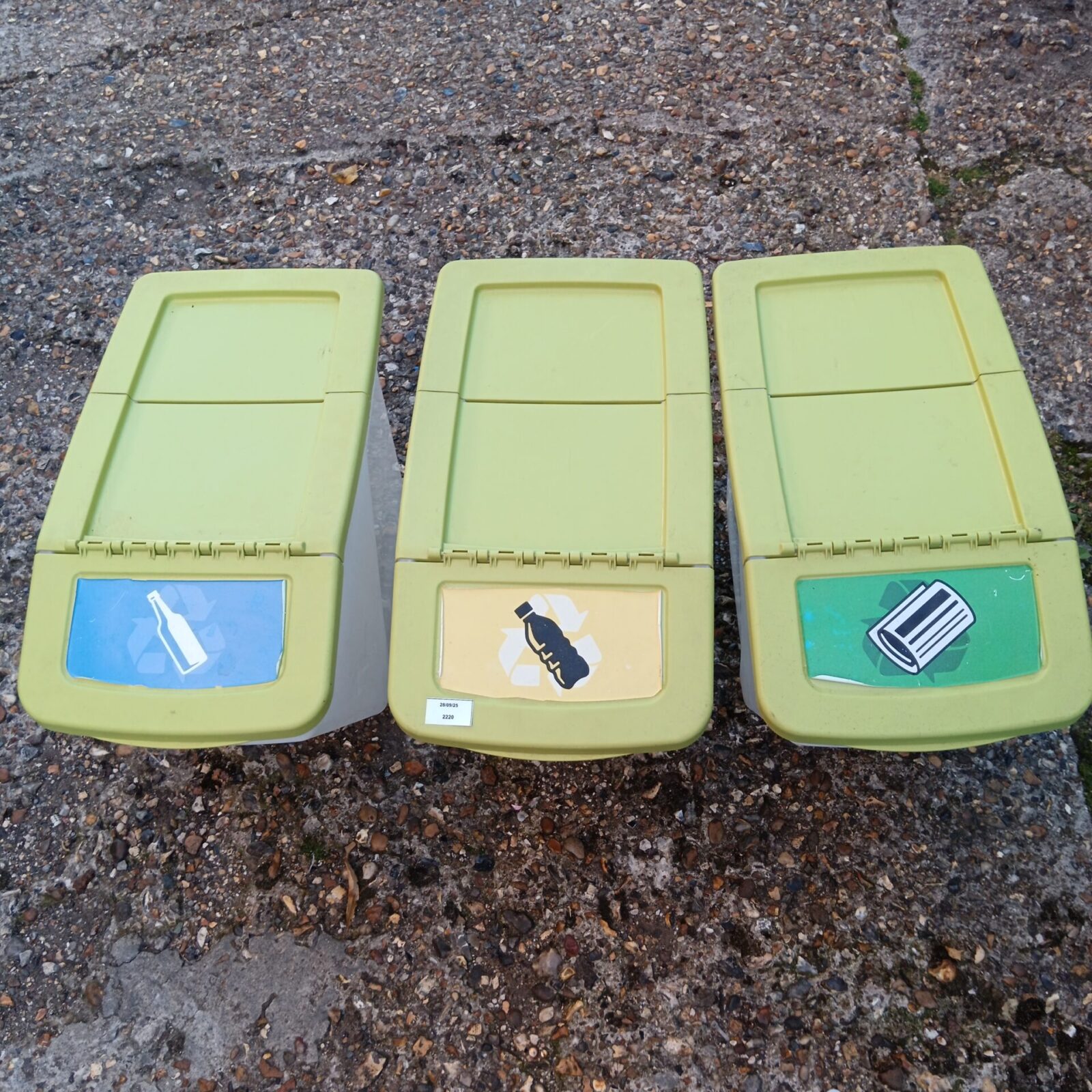 Set of three green plastic recycling bins for waste sorting.