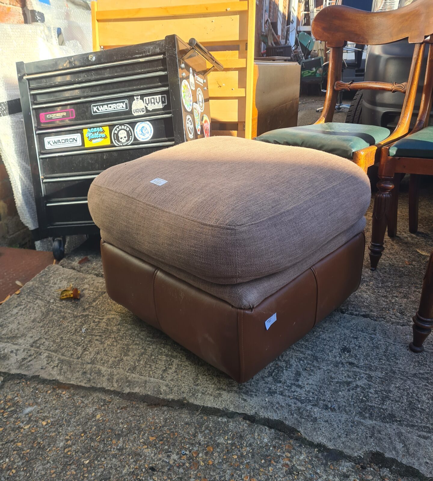 Brown leather Thomas Lloyd ottoman with storage capacity.