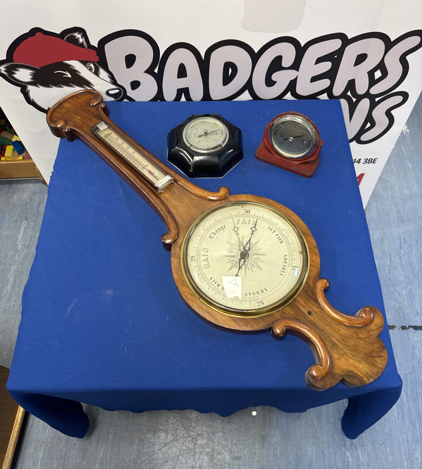 Lot of three vintage barometers on a blue surface.