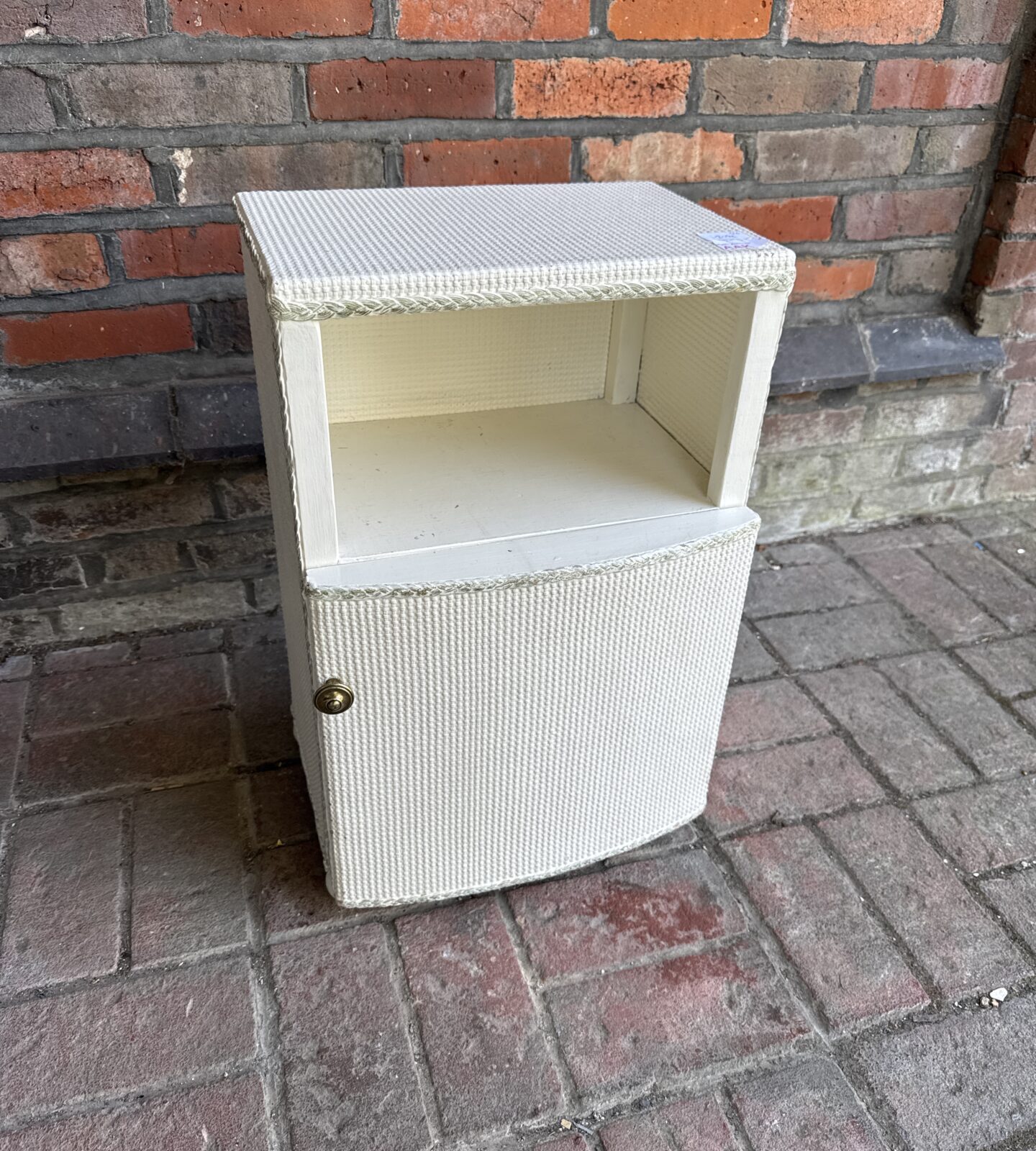 Vintage loom bedside cabinet with woven texture and single door.