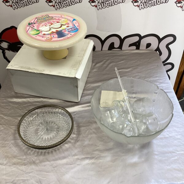 Vintage rotating cake stand with punch bowl and glasses on display.