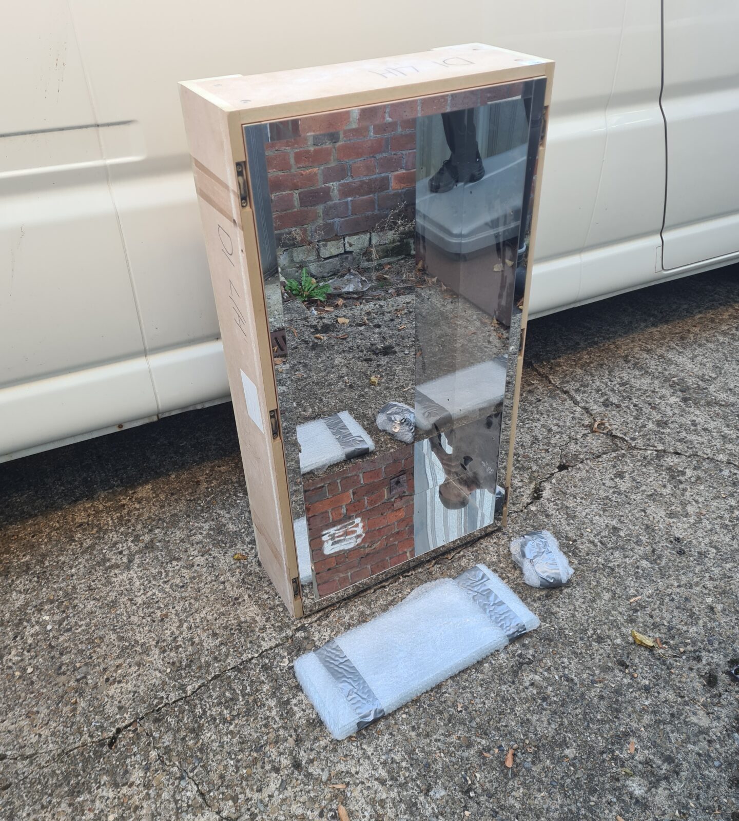 Vintage wooden mirror storage shelf unit with mirrored door.