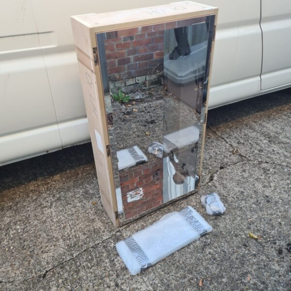 Vintage wooden mirror storage shelf unit with mirrored door.