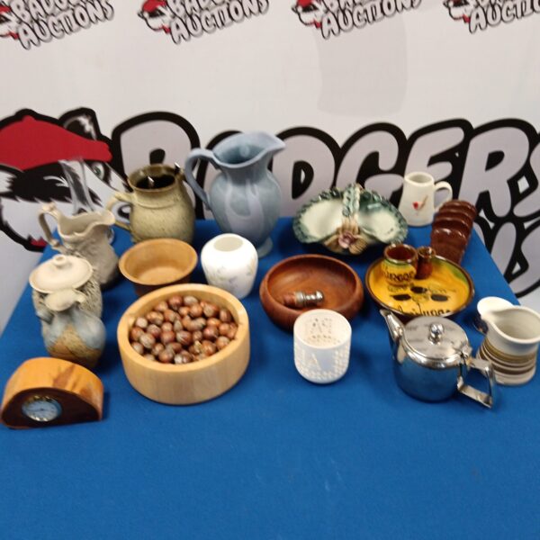 Collection of studio pottery and wooden bowls on a blue surface.