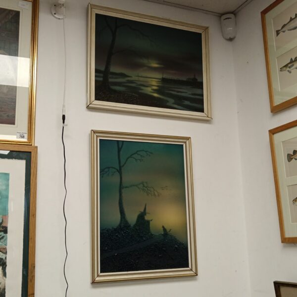 Pair of framed Halloween horror paintings on a white wall.