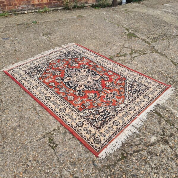 Detailed patterned Moroccan rug with red and beige tones.