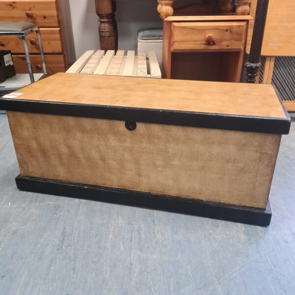 Front view of an antique pine storage trunk with a weathered finish.
