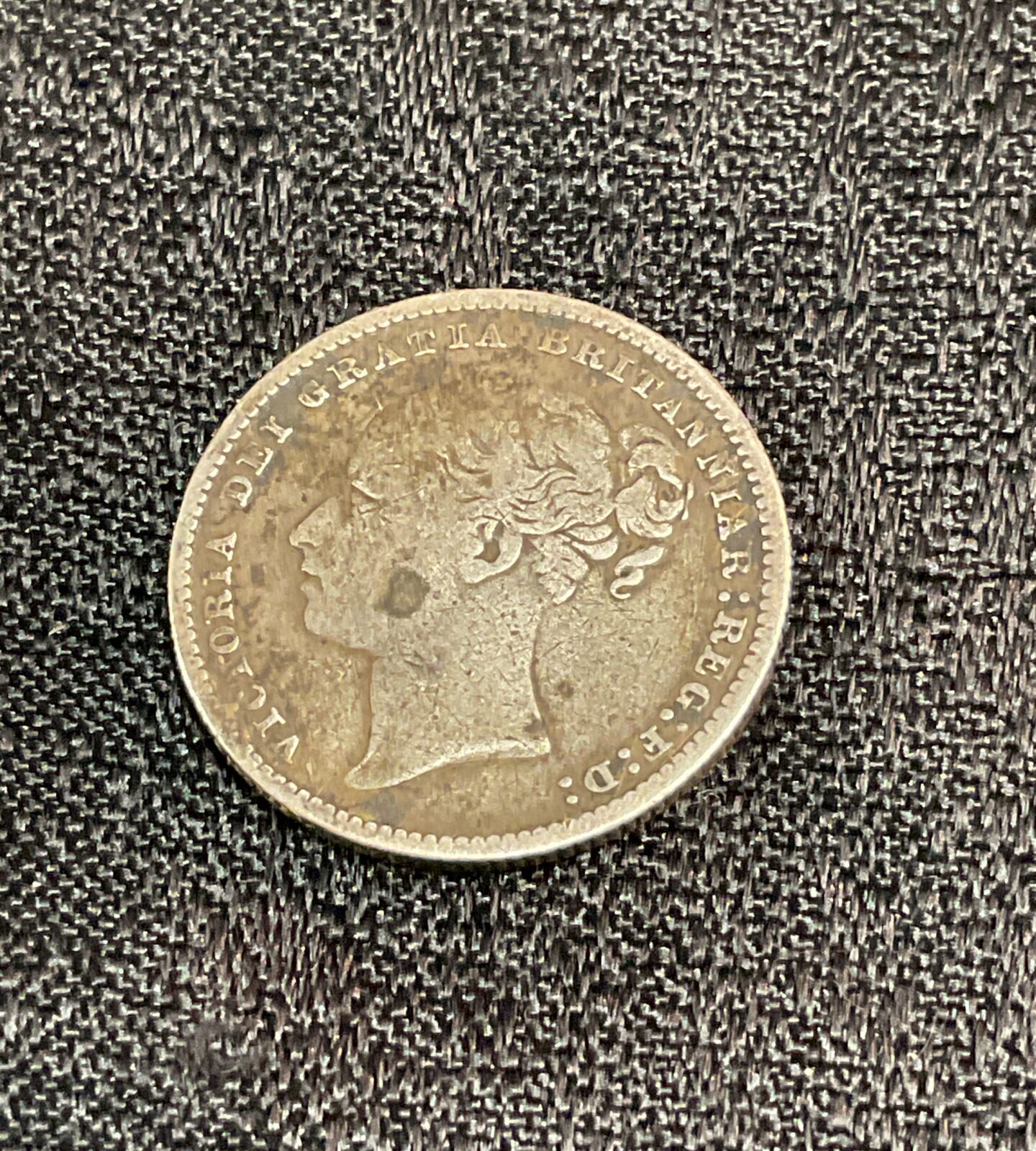 Victorian 1885 shilling coin with Queen Victoria portrait.