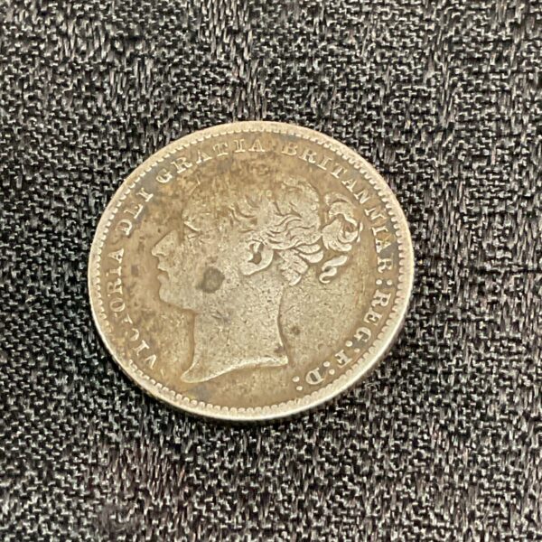Victorian 1885 shilling coin with Queen Victoria portrait.