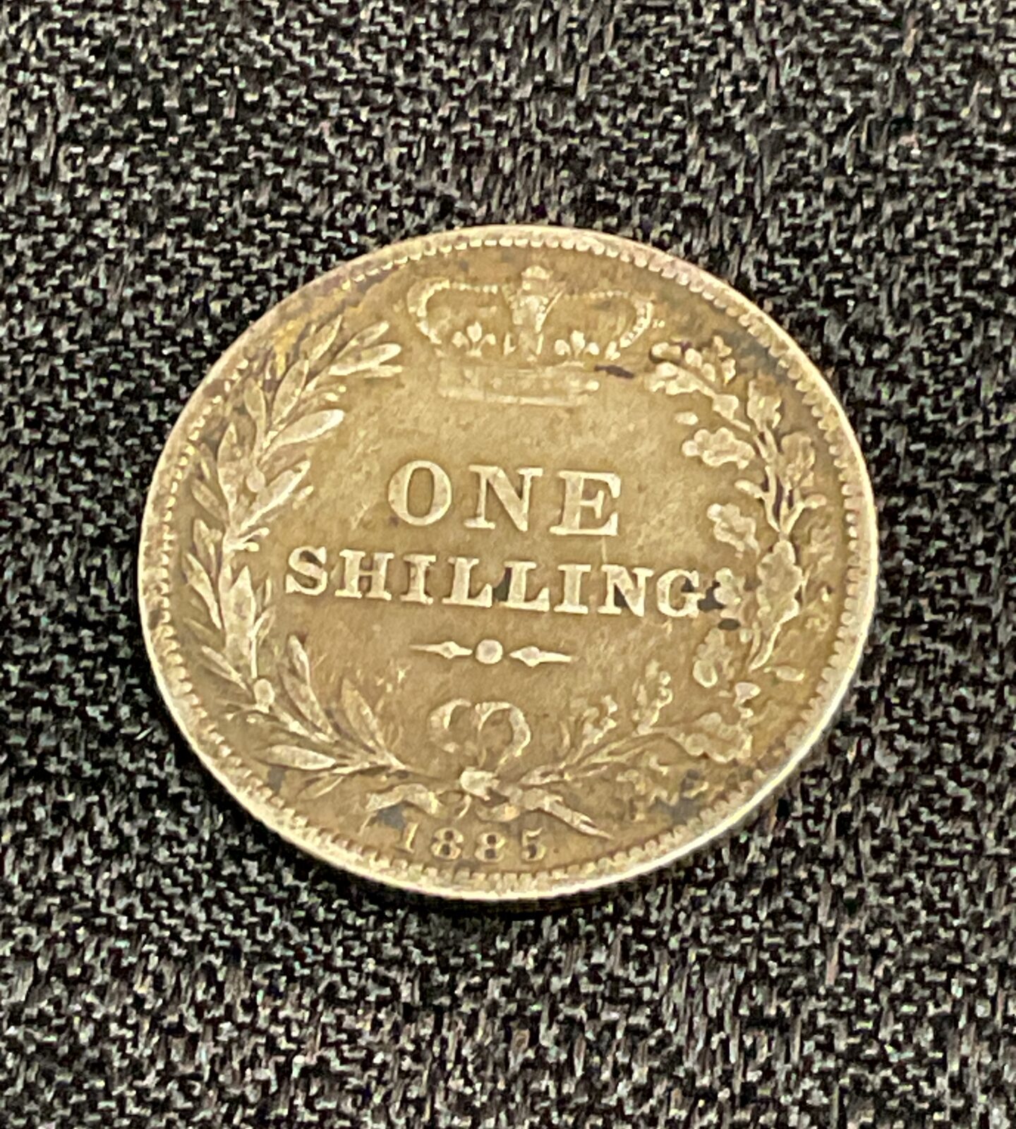 Reverse side of an 1885 Victorian silver shilling coin.