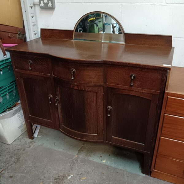 Vintage 1930s serpentine sideboard with mirrored back and elegant curves.