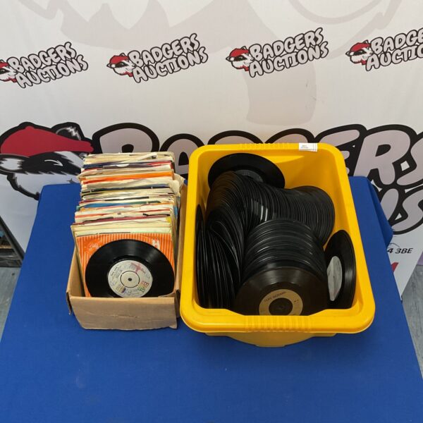 Mixed genre 7” vinyl records in a plastic container.