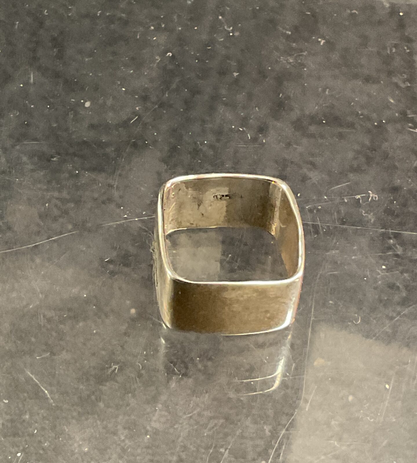 Close-up of a 925 silver square ring, minimalist design.