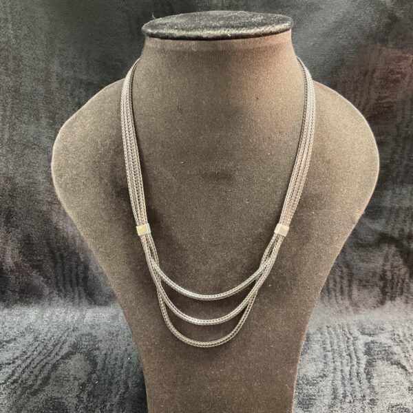 Elegant 925 silver three-strand necklace on display.