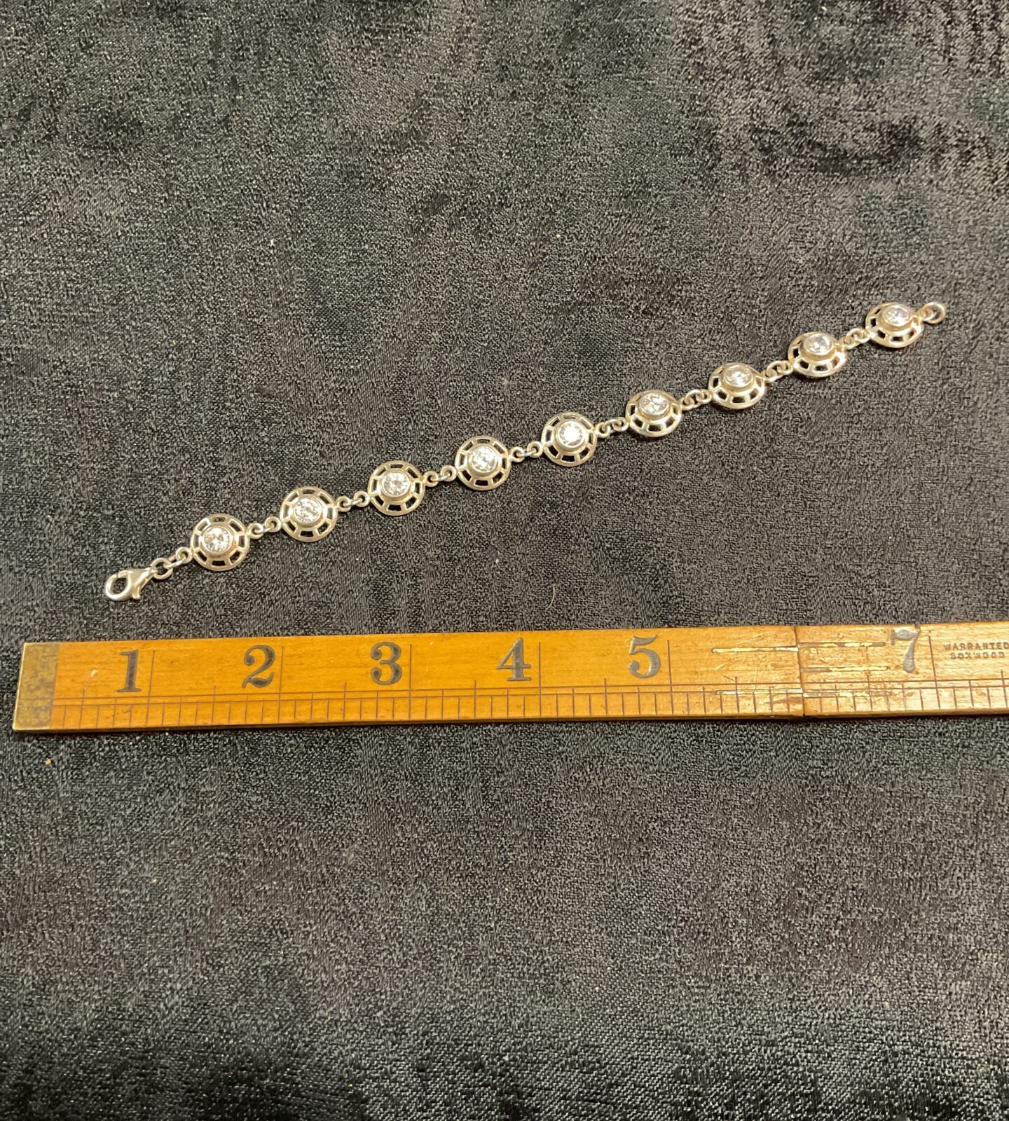 Close-up of a 925 silver bracelet with white stones.