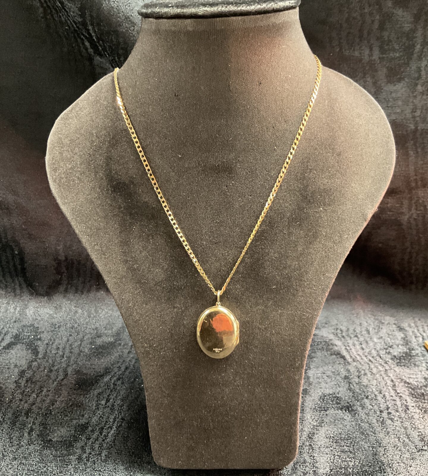 Vintage 9ct gold locket and chain necklace on display.