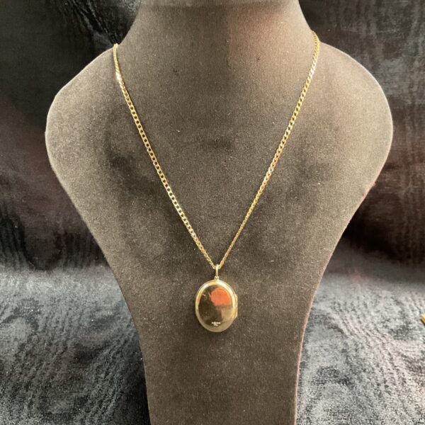 Vintage 9ct gold locket and chain necklace on display.