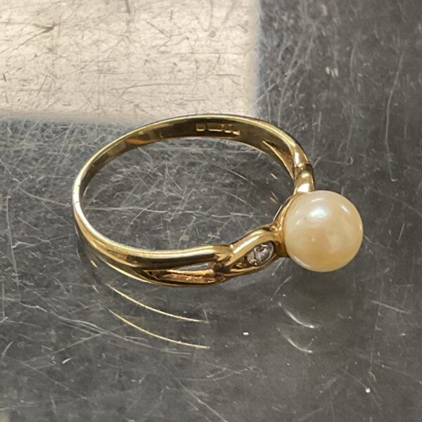 Elegant 9ct gold ring with a pearl and white stone details.