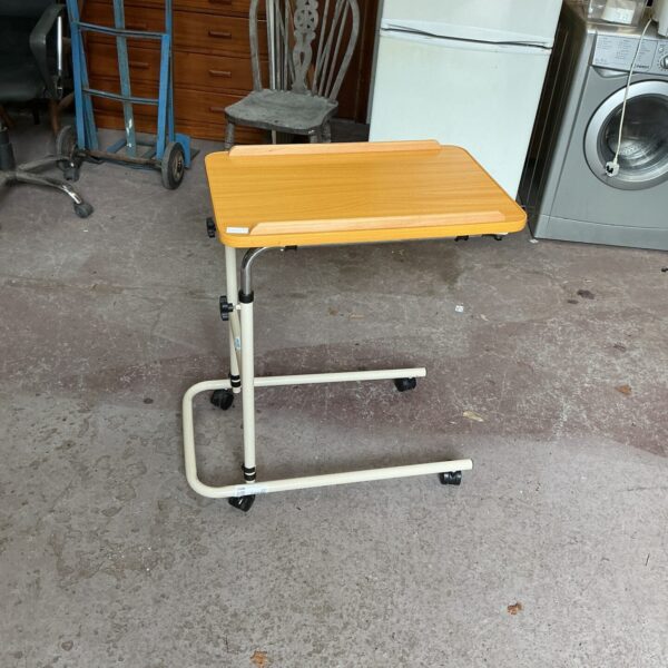 Adjustable bedside table on wheels with laminate top.