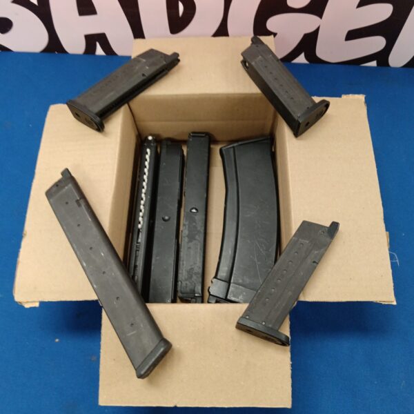 Lot of dark coloured airsoft rifle magazines in a cardboard box.