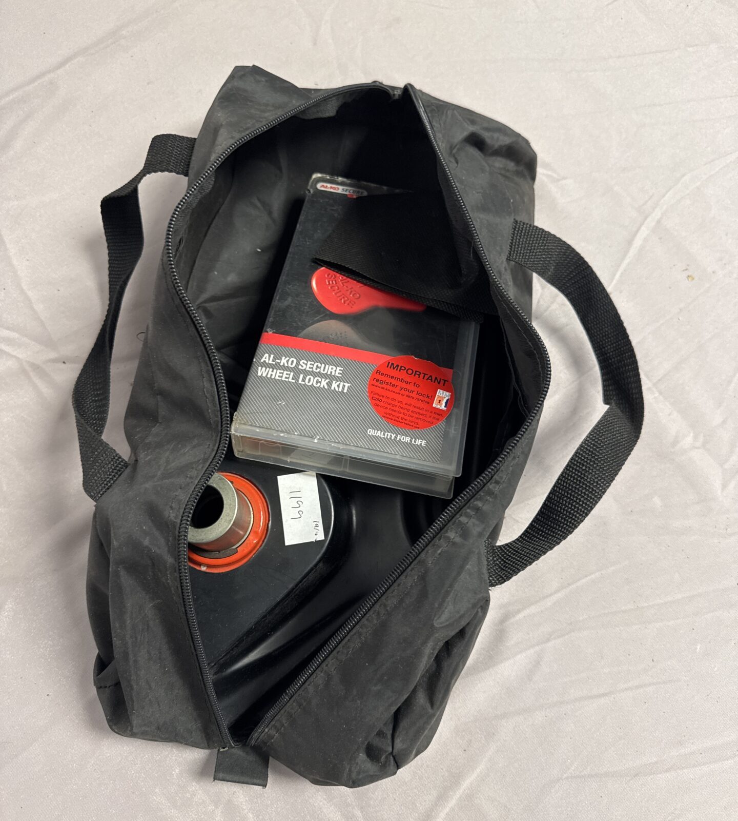 Open black bag showing Al-ko wheel lock kit components.