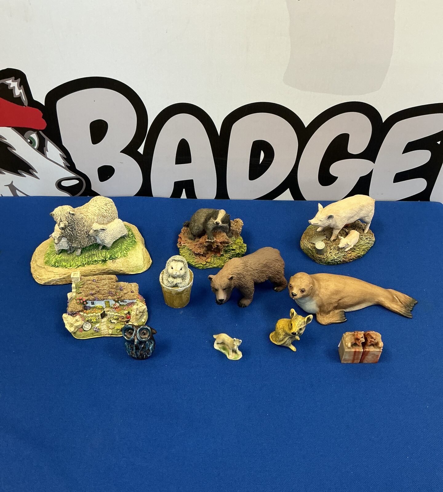 Detailed collection of animal figurines including a hand-painted badger.