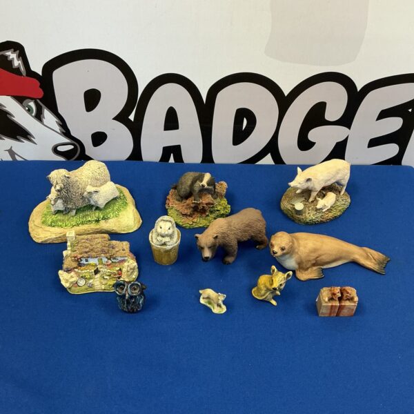 Detailed collection of animal figurines including a hand-painted badger.
