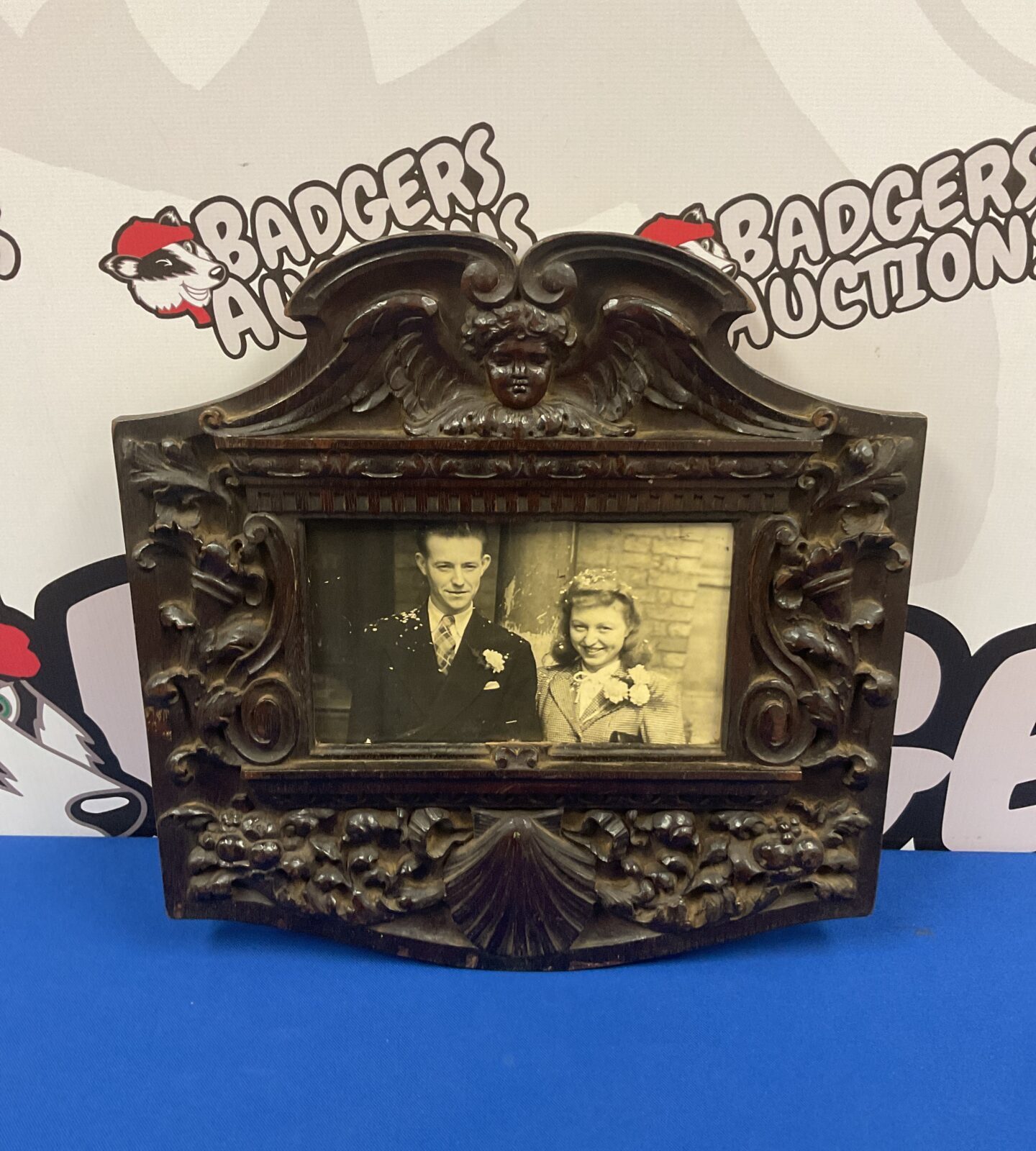 Intricately carved antique Black Forest photo frame with a vintage photograph.