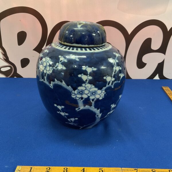 Antique Chinese ginger jar lid with blue and white floral design.