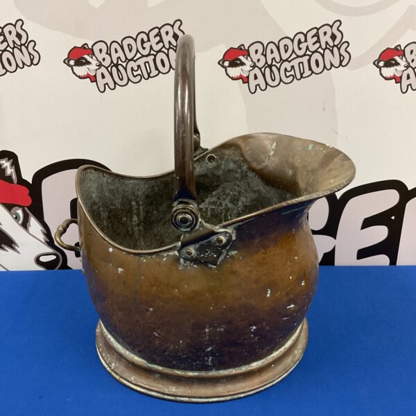 Antique copper helmet coal scuttle with patina and handle.