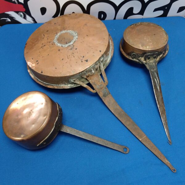 Lot of three antique copper cooking pans with iron handles.
