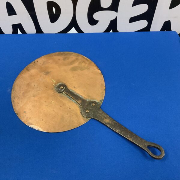 Antique copper pot lid with iron handle, vintage kitchenware.