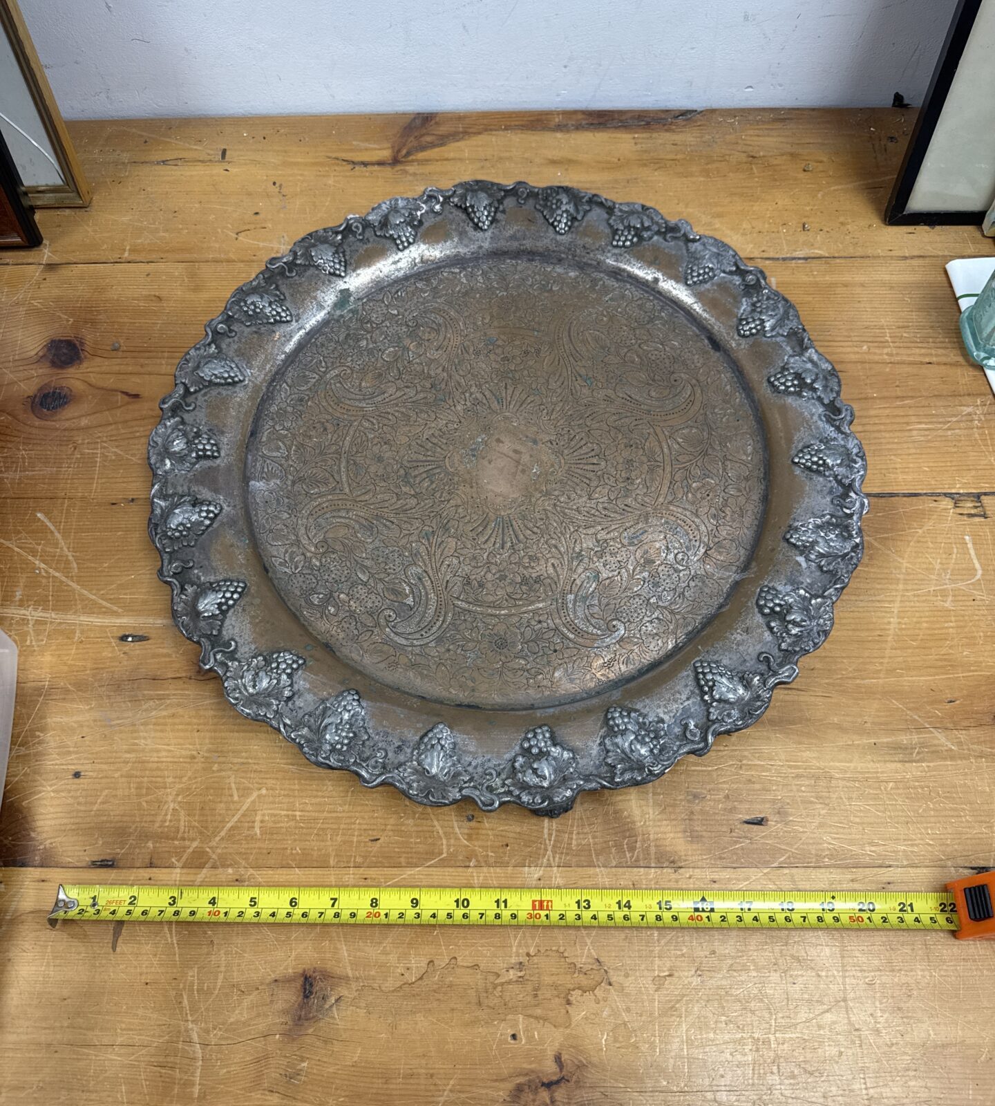 Ornate antique copper serving tray with embossed floral design.
