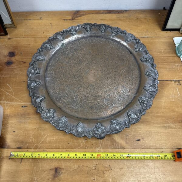 Ornate antique copper serving tray with embossed floral design.
