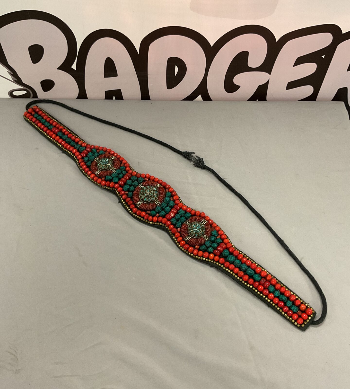 Antique coral belt with vibrant beads and fabric detail.