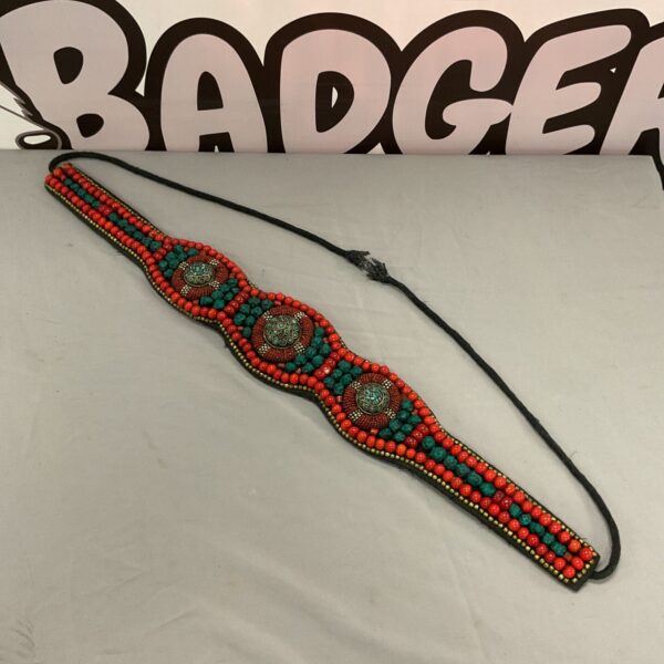 Antique coral belt with vibrant beads and fabric detail.