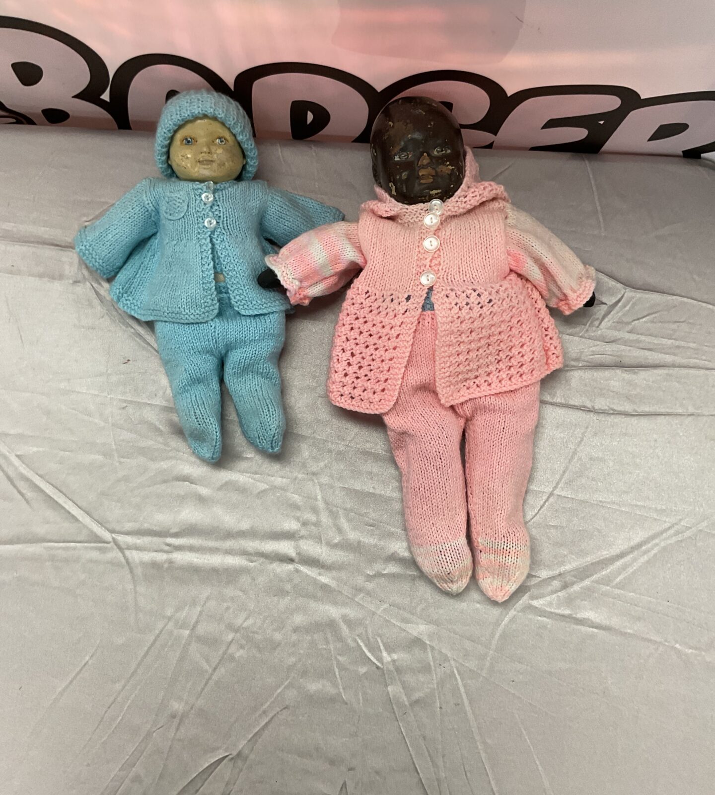Antique doll pair in knitted outfits, vintage collectible toys.