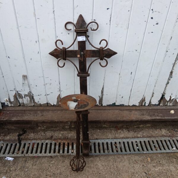 Antique iron crucifix sconce with ornate detailing for wall mounting.
