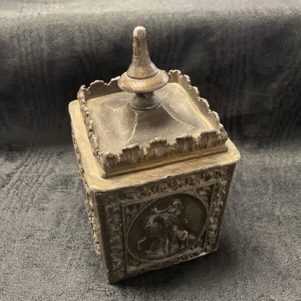 Intricate antique lead tobacco caddy with carved figures.