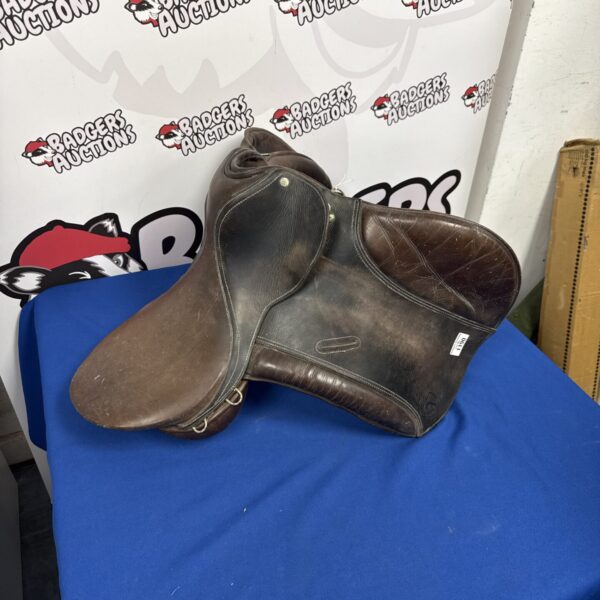 Front view of antique leather horse saddle with tooling.