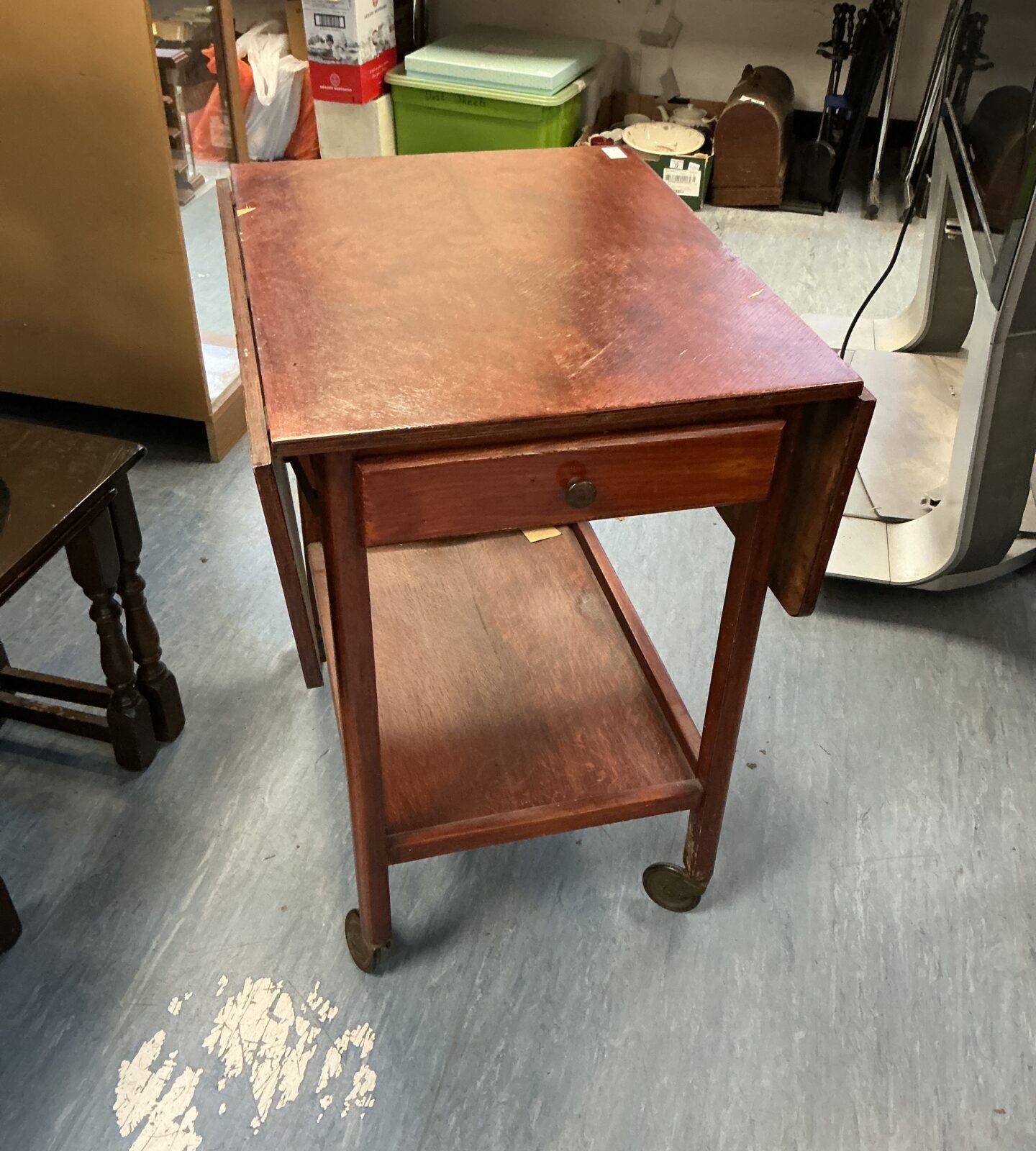 Side view of antique mahogany tea trolley with extending leaves.