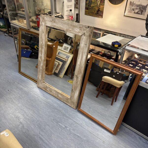 Large antique mirror with bevelled glass and ornate frame.
