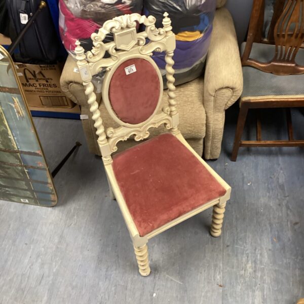 Antique oak hall chair with carved details and red upholstery.
